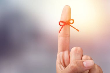 Bulanık arka plan üzerinde işaret parmağına ip yay