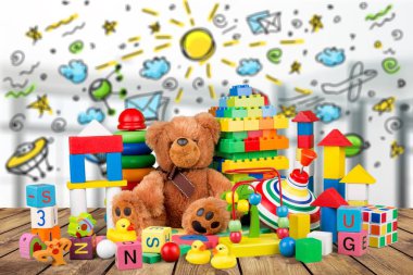 cute teddy bear and bright toys on wooden table  clipart
