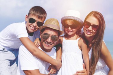 Genç ve mutlu bir aile sahilde vakit geçiriyor.