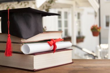 Mezuniyet şapkası, kitaplar ve diploma. 