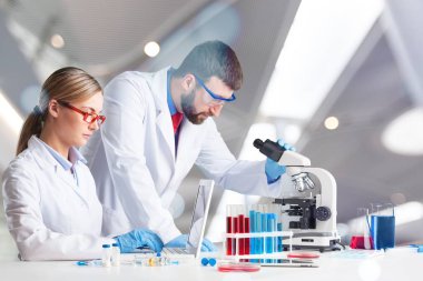 Laboratuvar ortamında araştırma yapan iki bilim adamı. 