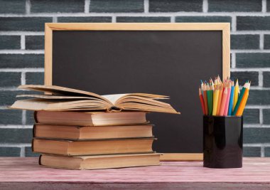 koyu arka plan üzerinde masaüzerinde yığın ve kitap ve kalem