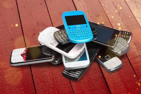pile of smartphones on wooden background