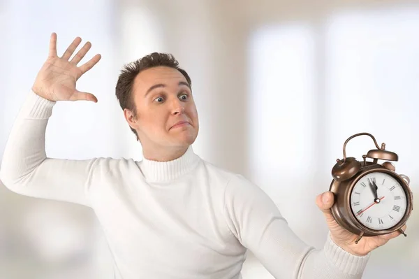 annoyed man holding alarm clock, deadline concept