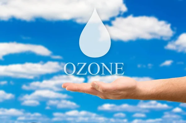 water in woman hand and drop on blue sky background, ozone concept
