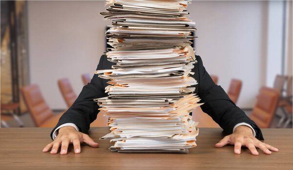 Перегруженный менеджер на рабочем месте на фоне
 