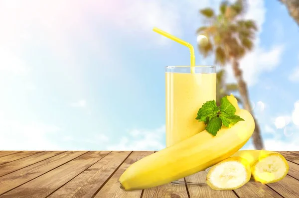 tasty banana juice in glass and raw bananas