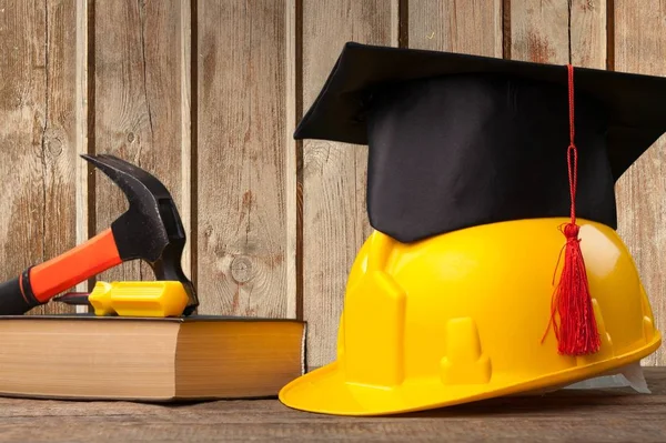 yellow hardhat and graduation hat