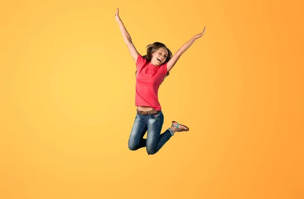 Menina Saltando Contra Fundo Amarelo — Fotografia de Stock