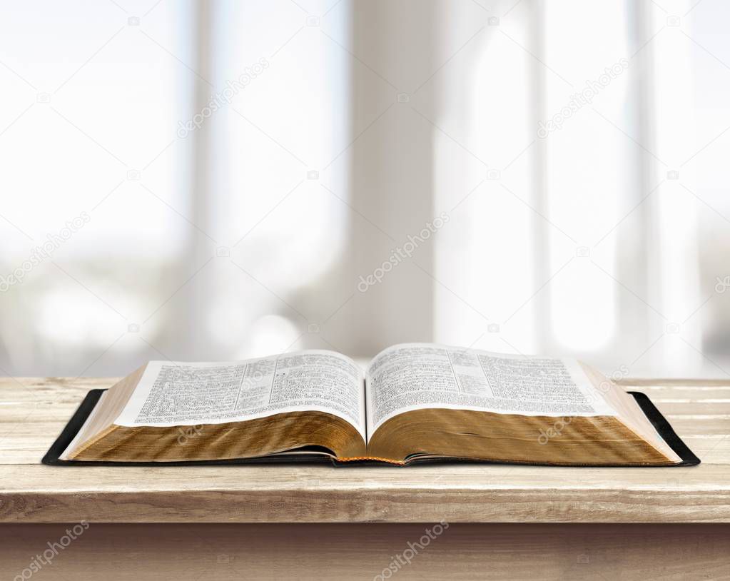opened holy bible book on table