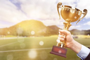 Altın Kupa arka planda tutan eller