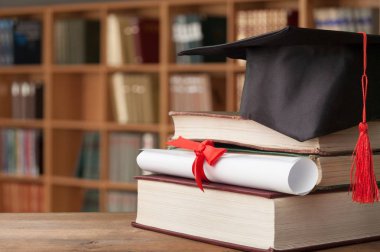 Mezuniyet şapkası, kitaplar ve diploma. 