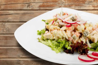 Jambonlu salata ve beyaz tabakta sebze.