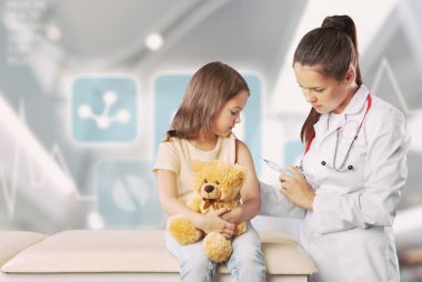 Genç doktor bir kıza iğne yapıyor.