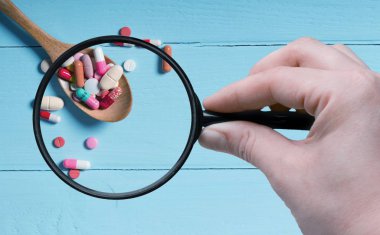 İlaçlar büyüteç ve mavi arka planda. en üstteki görünüm