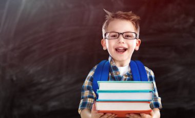 Küçük okul çocuğu kitap tutuyor.