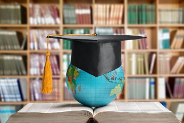 Mezuniyet şapkası ve kitabı içinde dünya 