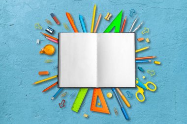 mavi arka planda not defteri ve okul malzemeleri