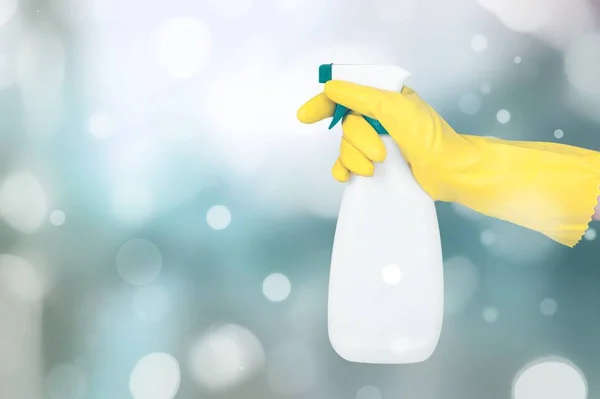 Guante de goma de mano sosteniendo una botella de aerosol — Foto de Stock