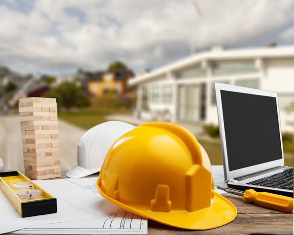 Желтая каска и инструменты на деревянном столе
