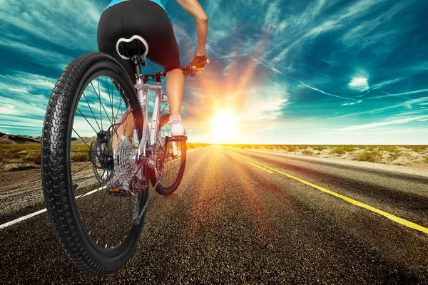 日落时骑自行车在路上 — 图库照片