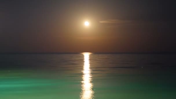 Fullmånen stiger över havet och Lunar bana i tid förfaller — Stockvideo