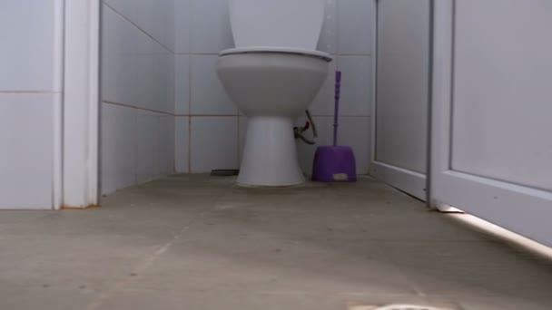 Cabinas sanitárias públicas. A câmera se move suavemente de baixo entre as cabines brancas do banheiro — Vídeo de Stock