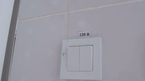 White Light Switch på vita väggen med inskriptionen 220 volt — Stockvideo