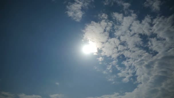 Σύννεφα κινούνται στο μπλε του ουρανού με φωτεινός ήλιος λάμπει. Πάροδο του χρόνου — Αρχείο Βίντεο