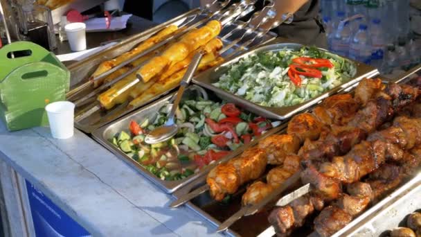 Gekookte straatvoedsel op de teller van de winkel. Shish Kebab op spiesjes, gegrilde champignons, groenten — Stockvideo