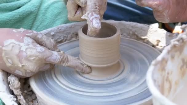 Las manos de los alfareros trabajan con arcilla en una rueda de alfarero — Vídeo de stock
