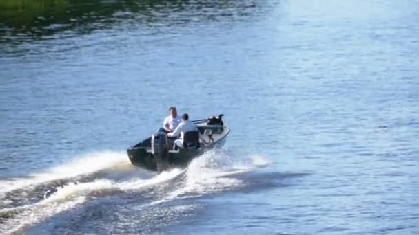 Les gens sur un bateau à moteur rapide naviguent le long de la rivière à Slow Motion — Video