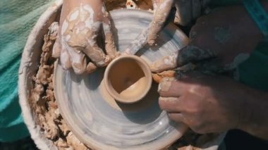 Üstten görünüm Potters eller çalışma üstünde a Potters tekerlek kil ile. Ağır çekim