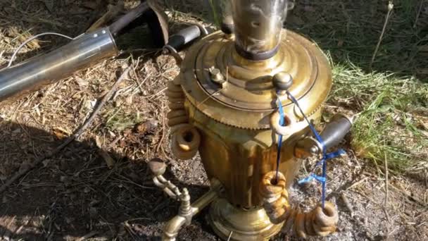 Big old Bronze samovar stands on the ground and prepares tea. — Stock Video