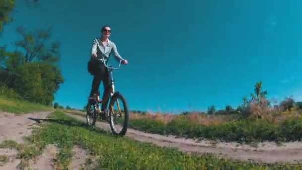 Genç kadın bir köyde kırsal bir yol boyunca Vintage bisiklet sürme — Stok video