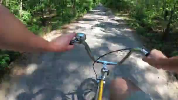 O homem está montando uma bicicleta em uma estrada rural na vila. Vista do peito. Desfasamento temporal . — Vídeo de Stock