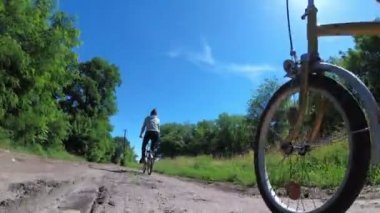 Genç kadın bir köyde kırsal bir yol boyunca Vintage bisiklet sürme