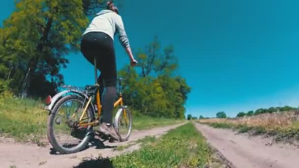 Fiatal nő lovaglás Vintage kerékpár egy vidéki úton a község — Stock videók