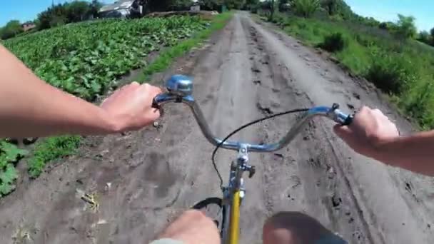 Ember lovaglás kerékpár egy vidéki úton a faluban. Nézd, a mellkas, a kerék — Stock videók
