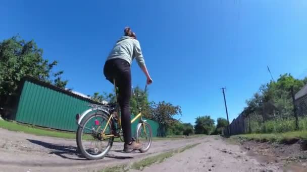 Junge Frau mit Oldtimer-Fahrrad auf einer Landstraße in einem Dorf — Stockvideo