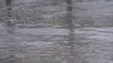 Yağmur damlaları bir su birikintisi şekillendirme kaldırım düşmek. Zaman atlamalı