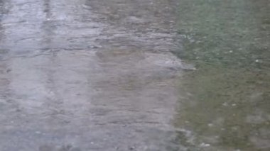 Yağmur damlaları bir su birikintisi şekillendirme kaldırım düşmek