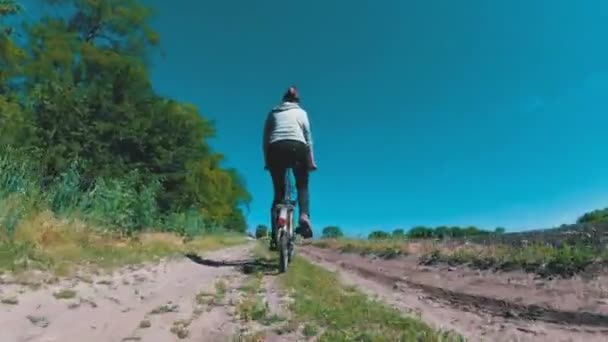 村の田舎の道に沿ってヴィンテージ自転車に乗る若い女性 — ストック動画