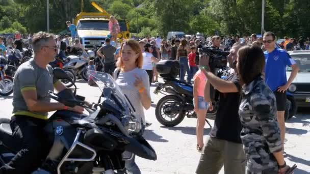 Jornalistas com uma câmera e um microfone são entrevistados no Festival Tarasova Mountain Moto — Vídeo de Stock