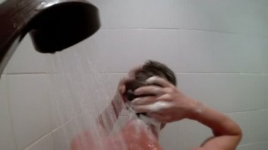 Adam kafasını duşta yıkar.