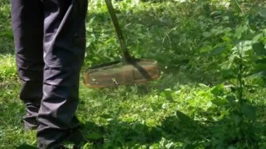 Adam Mows yavaş çekimde taşınabilir bir çim biçme makinesi kullanarak çimen