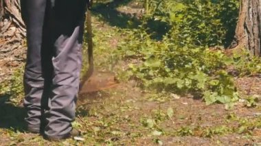 Adam Mows yavaş çekimde taşınabilir bir çim biçme makinesi kullanarak çimen