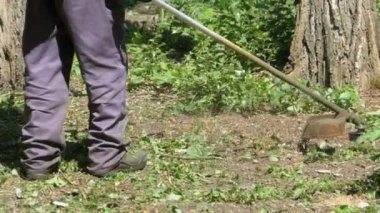 Adam Mows yavaş çekimde taşınabilir bir çim biçme makinesi kullanarak çimen