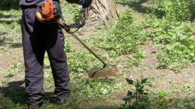 Adam Mows yavaş çekimde taşınabilir bir çim biçme makinesi kullanarak çimen