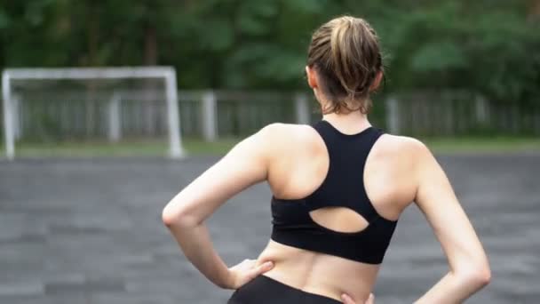 Giovane atleta donna in abito sportivo impegnata in forma fisica sul campo sportivo nel parco . — Video Stock
